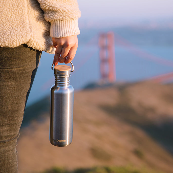 27oz-reflect-with-bamboo-cap-k5 K27SSLRF-BS-BAMBOO_reflect_bottle_bridge_lifestyle.jpg